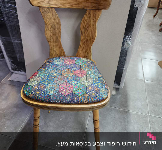 כיסא עם ריפוד צבעוני על רצפת אריחים אפורה